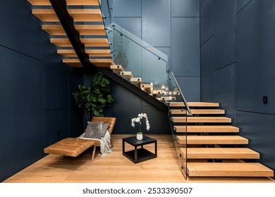 Modern interior with wooden floating staircase, glass railing, lounge chair, plant, and small table with flower arrangement. - Powered by Shutterstock