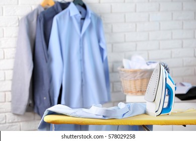 Modern iron and clothes in dry-cleaning salon