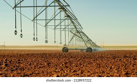 Modern irrigation system sprays water for the new crop at large Texas farm. Center pivot sprinkler mechanism.