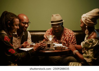 Modern jazz band members sitting at table in local bar discussing new songs - Powered by Shutterstock