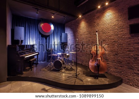 Modern jazz bar interior design, stage with black piano and cello