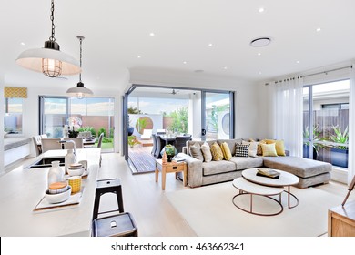Modern kitchen area attached to the living room beside a patio and dinner area near to outside entrance, there are hanging lamps - Shutterstock ID 463662341