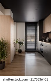 Modern Kitchen With Black Ceiling, Wooden Furniture And Big Window With Black Blinds