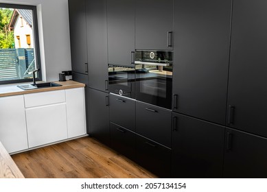 Modern Kitchen With Black Fronts, Built In Oven And Microwave, Vinyl Panels On The Floor.