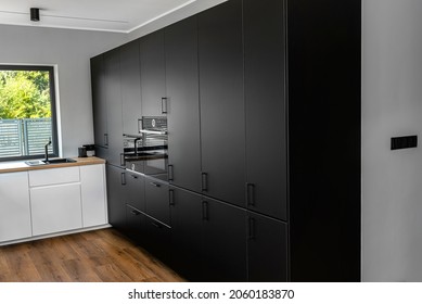 Modern Kitchen With Black Fronts, Built In Oven And Microwave, Vinyl Panels On The Floor.