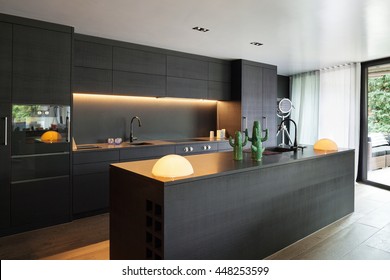 Moderne Küche mit schwarzem Mobiliar und Holzboden
