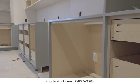 Modern Kitchen Cabinets Installation in Progress, Unfinished Light Wood Cabinetry with Gray Frames
