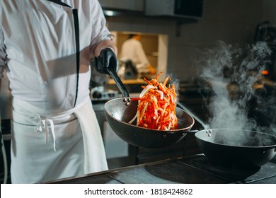 Modern kitchen. Cooks prepare meals on the stove in the kitchen of the restaurant or hotel. The fire in the kitchen