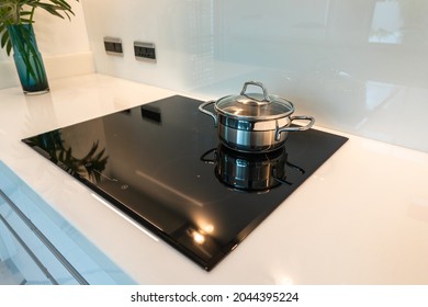 Modern kitchen interior with Black ceramic induction stove , electric hob stove cooker with white granite countertop.