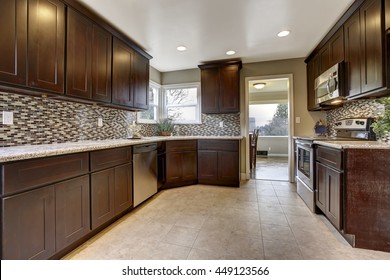 Modern Kitchen Interior With Dark Brown Storage Cabinets With Granite Counter Tops And New Tile Floor