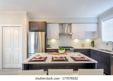 Modern Kitchen Interior With Island And Cabinets In A Luxury House Set For Dinner