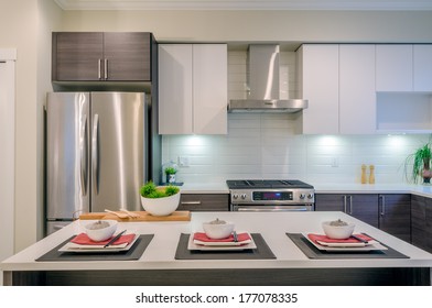 Modern Kitchen Interior With Island And Cabinets In A Luxury House Set For Dinner