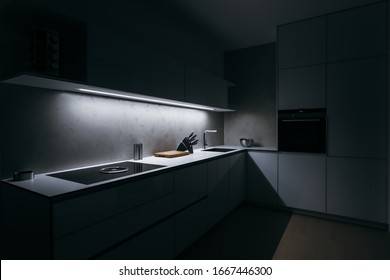 Modern kitchen in minimalist design during night with LED light strip, modern appliances and premium materials such as glass, concrete and wood. Kitchen is complemented by basic kitchen utensils.