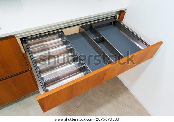 Modern kitchen, Open drawers, Set of\
cutlery in kitchen drawer. Utensil divider for\
drawers.