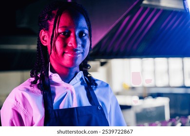 In a modern kitchen restaurant a confident female chef in uniform smiles at the camera. Professional expertise successful in her occupation presenting delicious food. - Powered by Shutterstock