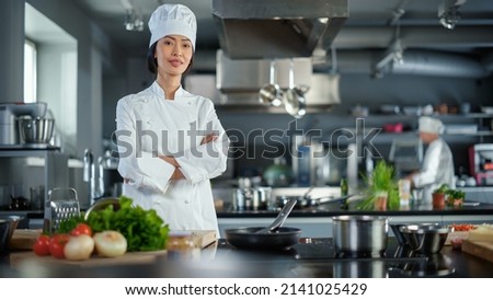 Modern Kitchen Restaurant: Portrait of Asian Female Chef, Crossing Arms and Looking at Camera Smiles. Professional Cooking Delicious and Authentic Food, Cuts Vegetables, Preparing Healthy Meal