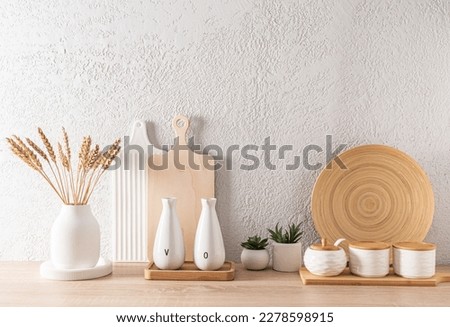 modern kitchen space in light colors. a set of various kitchen utensils on a wooden countertop. front view. ECO items
