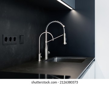 Modern kitchen washbasin with chrome faucet (water mixer) close-up.