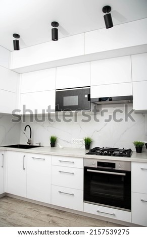 Modern kitchen in white and black. Beautiful new interior. Built-in microwave oven, hob and electric oven, technology Foto d'archivio © 