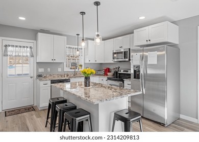 A modern kitchen with white walls and cabinets, featuring stainless steel appliances - Shutterstock ID 2314209813