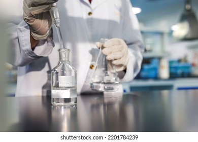 Modern laboratory scientist conducting an experiment mixing the compounds - Powered by Shutterstock