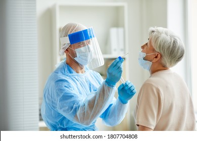 Modern laboratory worker wearing personal protective equipment testing senior woman for coronavirus using nasal swab method - Powered by Shutterstock