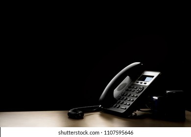 modern landline phone on the table and darrk background