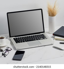 modern lap top template mock up on white and clean work desk with blank screen Workspace desk, laptop, coffee cup and pen laptop mock up screen view. work from home concept - Shutterstock ID 2140148315