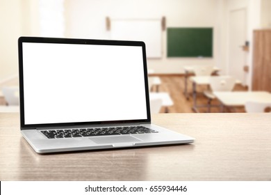 Modern laptop with blank screen on table in classroom