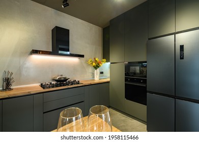 Moderne große, luxuriöse, dunkelgraue Küche, Schublade mit Küchenutensilien gezogen