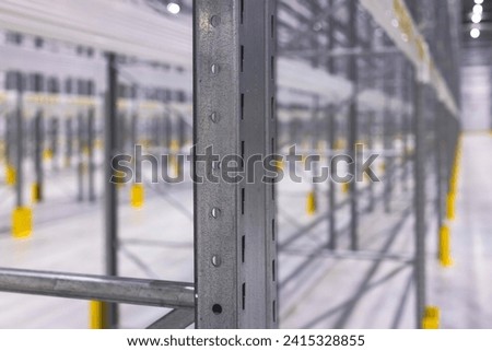 Modern large warehouse space interior, new and modern distribution storage with rows of the empty high shelves and racks, concrete and steel, logistics complex inside
