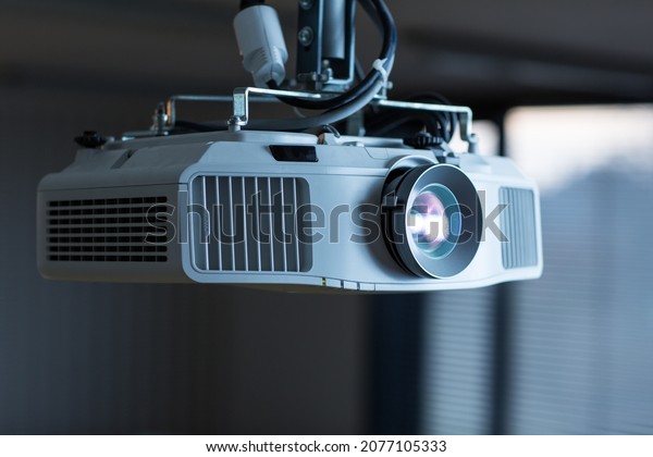 Modern laser projector in a conference\
room . LCD Projector technology video\
presentation