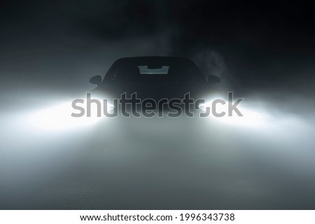 Modern LED Car Headlights in Dense Fog Automotive Industry Theme. Hard Road Driving Conditions. 