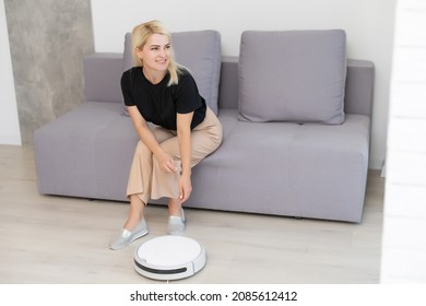 Modern Life Concept, Woman Relaxing , Automatic Robotic Hoover Clean The Room While