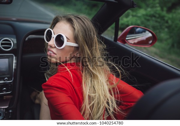 Modern life, luxury, city, glamour.\
Businesswoman or pretty woman in convertible car. Business trip or\
commanding, happy girl driver. Sexy woman drive car, fashion,\
beauty. Travel and summer\
vacation.