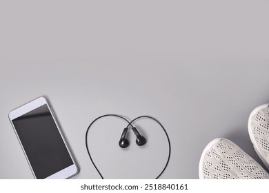 Modern lifestyle essentials: smartphone, earbuds, and sneakers for active living and music enjoyment. - Powered by Shutterstock