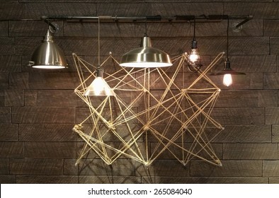 Modern Light Fixtures Hanging In Front Of Complex Geometrical Design. Abstract Interior Design Modern And Minimal. Light Bulbs Displaying Brightly.