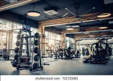 Modern light gym. Sports equipment in gym. Barbells of different weight on rack. - Shutterstock ID 721723381