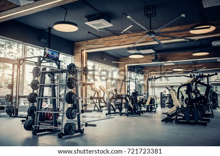 Modern light gym. Sports equipment in gym. Barbells of different weight on rack.