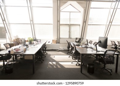 Modern Light Spacious Office Room Interior. Computers On Tables Black Chairs On Wheels, Sunlight Through The Panoramic Windows. Comfortable Contemporary Coworking Area For Work During Break, No People