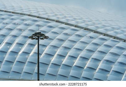 A modern light support on the background of a futuristic roof of a modern building. The concept of modern construction and architecture