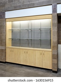 A Modern, Lighted Display Cabinet, With Tempered Glass Shelving, For Showing Trophies From The Achievements Of School Sports Teams.