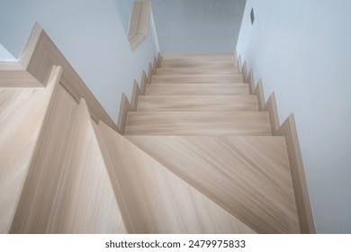 A modern, light-toned wooden staircase inside a contemporary home, showcasing clean lines and minimalistic design. - Powered by Shutterstock