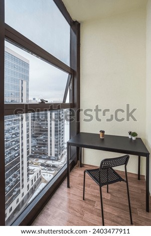modern living room. modern living room with balcony. window view on downtown city with skyscrapers. decoration of the balcony. room of apartment with balcony. interior of the room with black frames