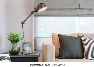 Modern Living Room With Black Lamp On Table Side And Glass Vase Of Plant