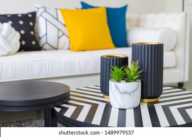 Modern Living Room With Blue, White And Yellow Pillow On Sofa. Coffee Table With Plant Pot And Gold Vase.