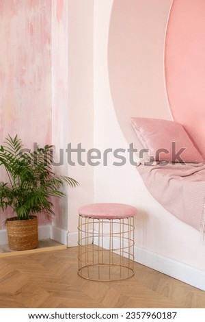 Modern Living room design vibrant interior with decorative arch on pink wall with pillows and plaid. Memphis style interior with niche arch and pouf for seat. Modern style conceptual interior room