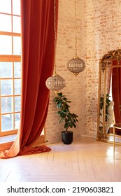 Modern Living Room In French Style. Stylish French Interior With Big Window And Curtains, Green Plant In Pot, David Sculpture, Vintage Gold Mirror And Crystal Chandeliers Against A Brick Wall.