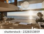 Modern living room overlooking ocean at sunset