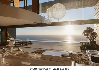 Modern living room overlooking ocean at sunset